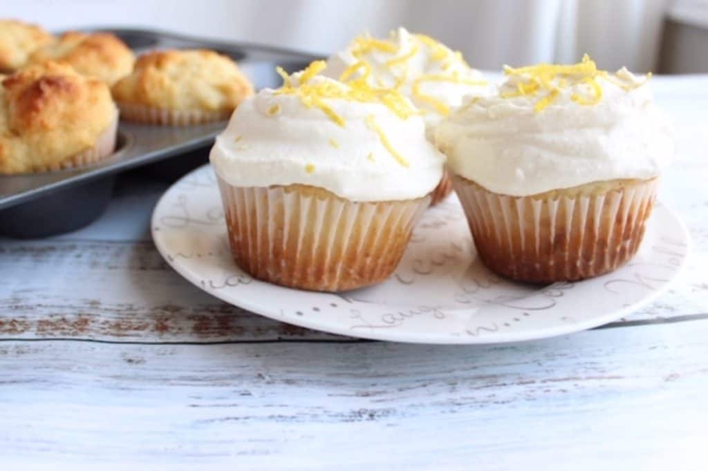 lemon and honey cupcakes on white plate with muffin tin in background