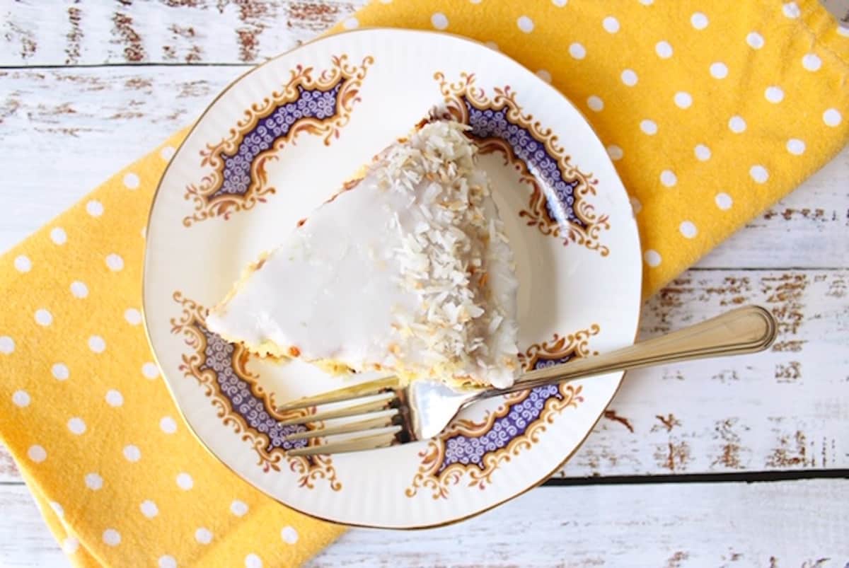 Slice of cake on white plate with yellow napkin