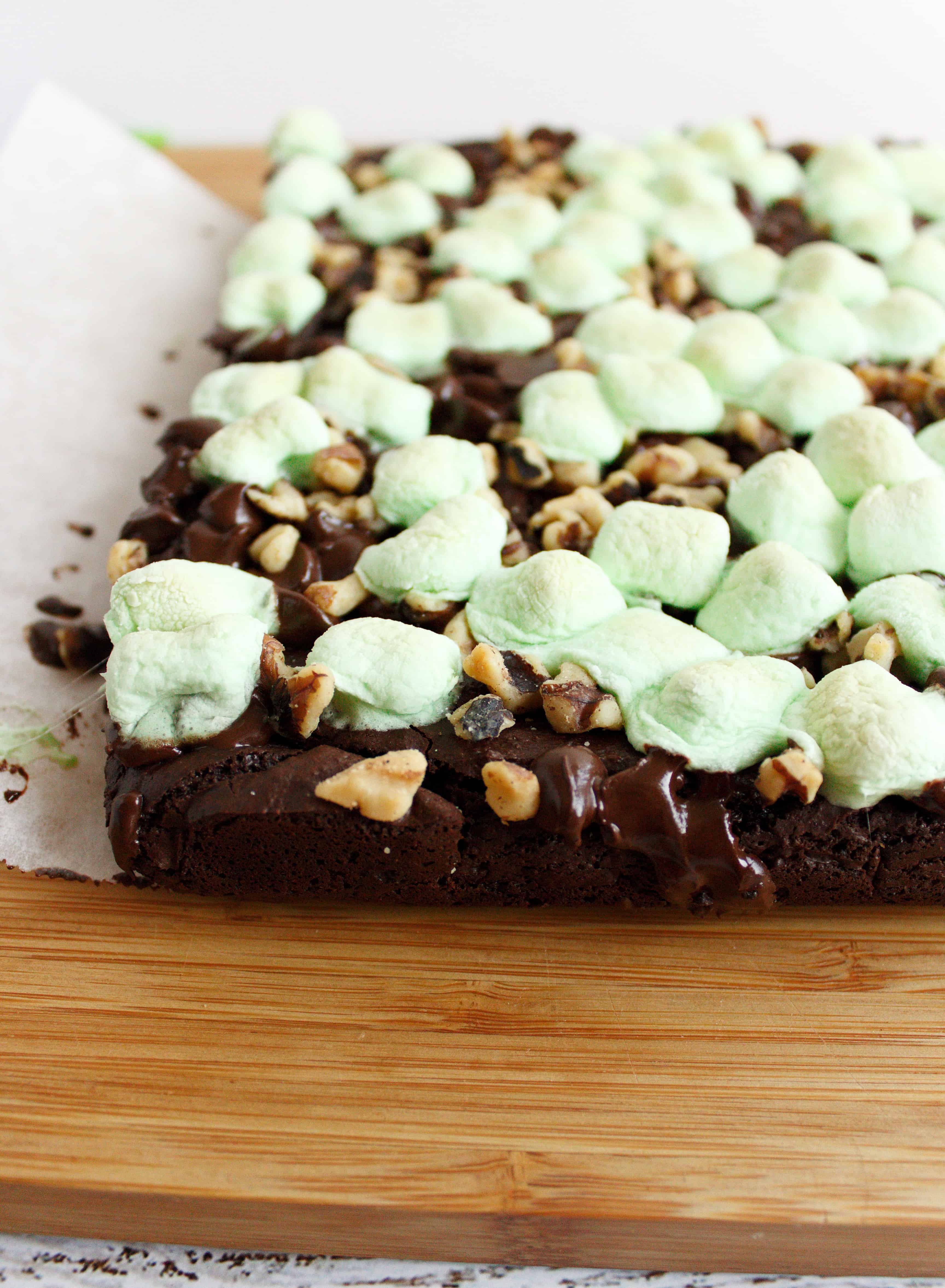 Brownies sit on a wooden cutting board