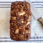 Full cake loaf on cooling rack with cutting knife