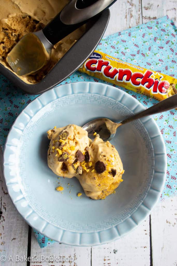 two scoops of crunchie ice cream in a blue bowl on a blue napkin