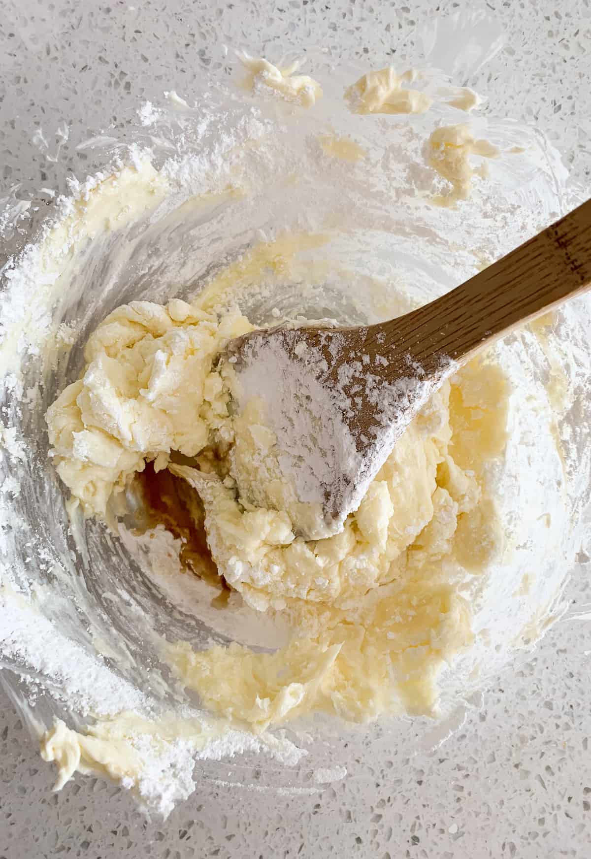 Adding powdered sugar to cream cheese and butter