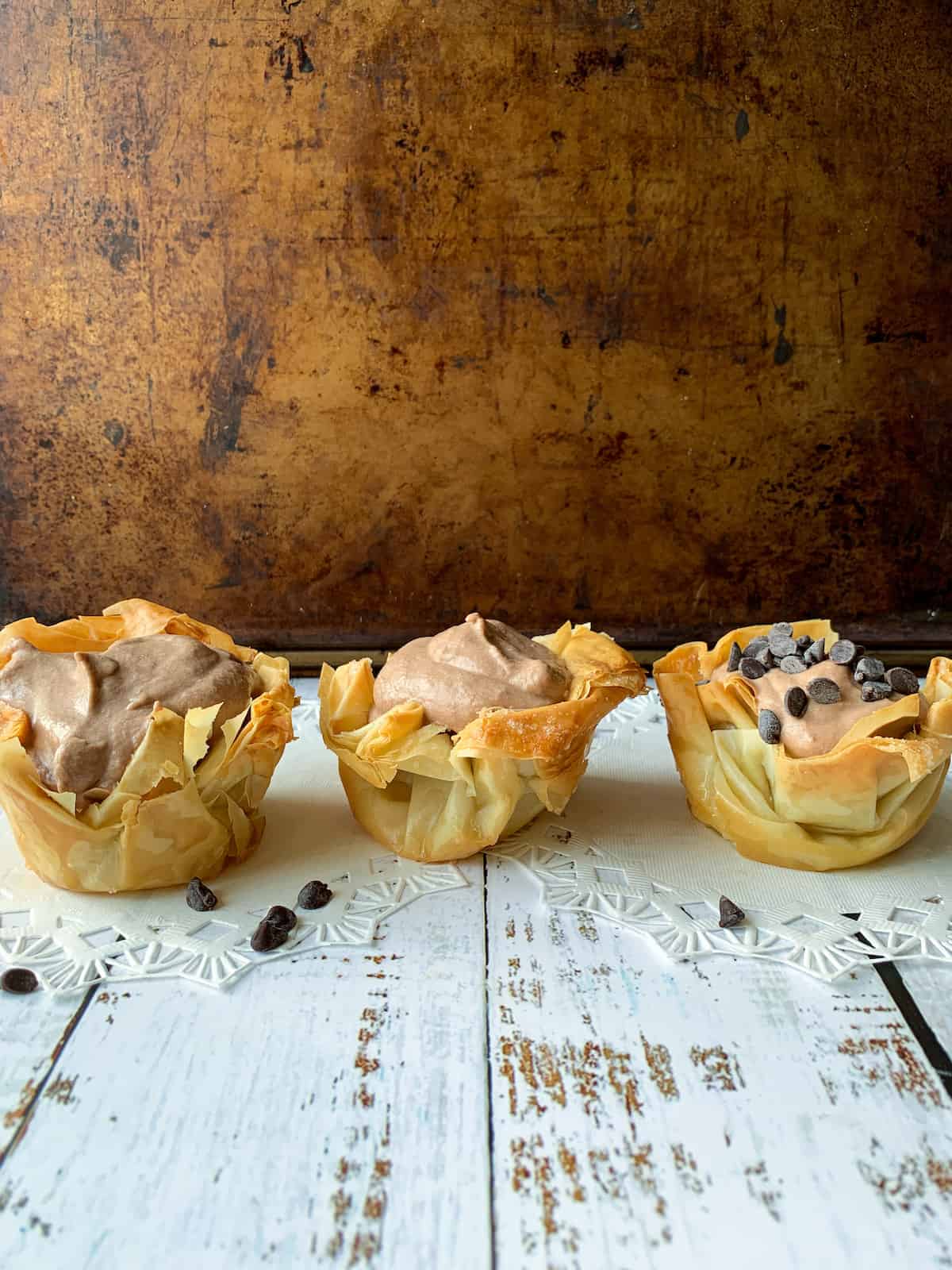 three phyllo nutella tarts in a row on a board