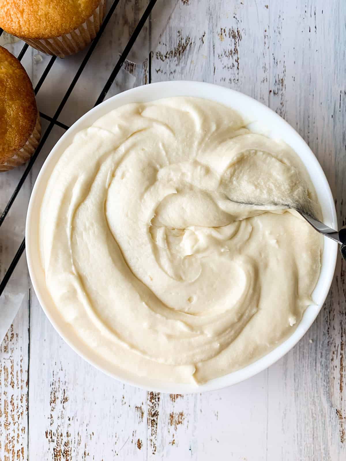 almond buttercream frosting in white bowl
