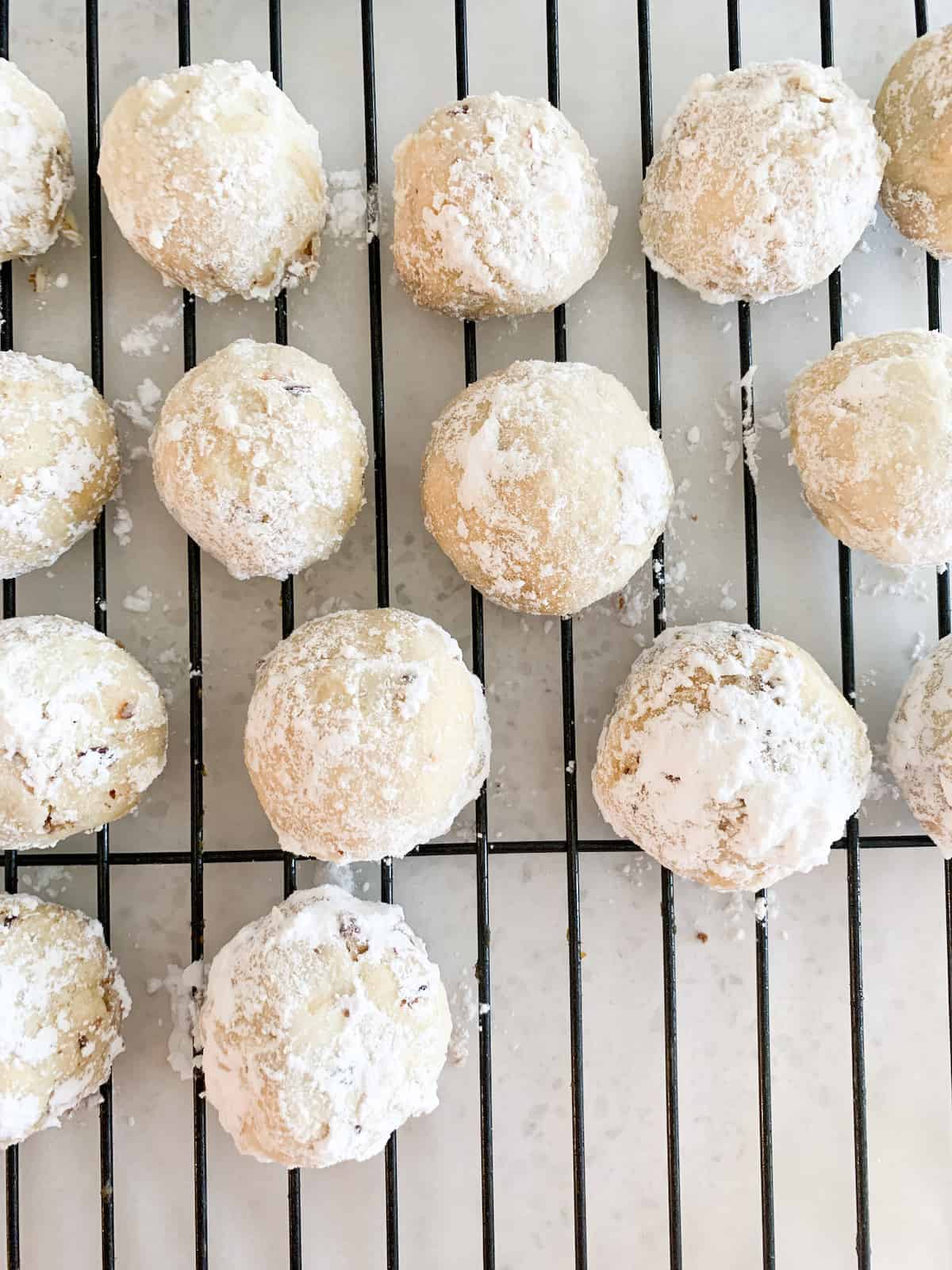 Mexican wedding cookies sitting on a wire rack