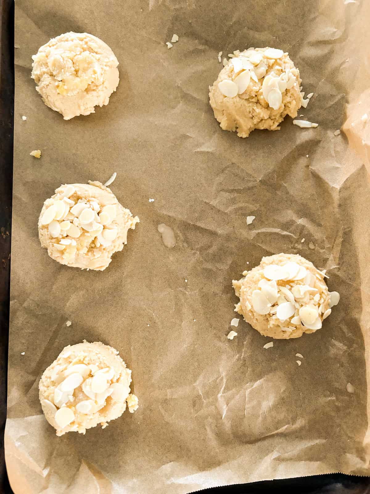 Almond cookie dough balls on cookie sheet