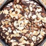 chocolate cake topped with chocolate chips and sliced almonds