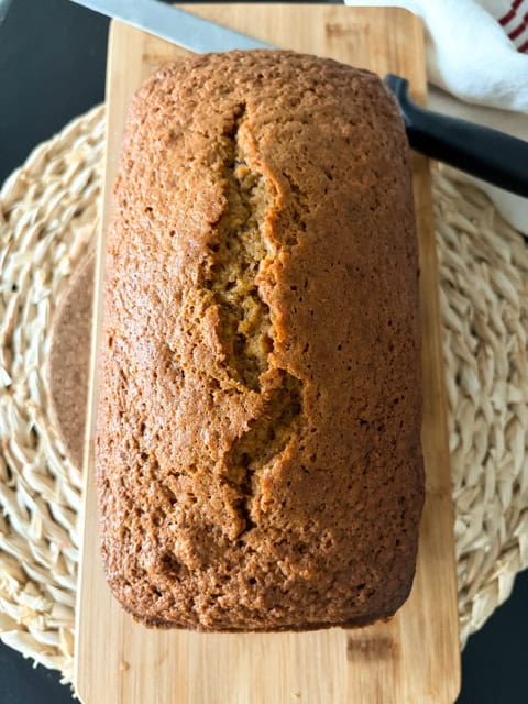 baked loaf of pumpkin bread on a wooden board
