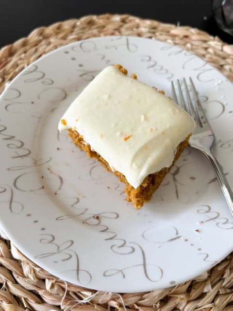 Looking down on a square of pumpkin cake with cream cheese frosting.