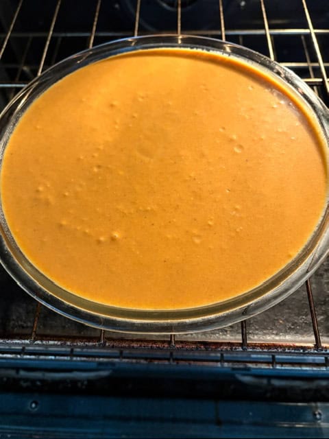 uncooked pumpkin pie in glass pie plate
