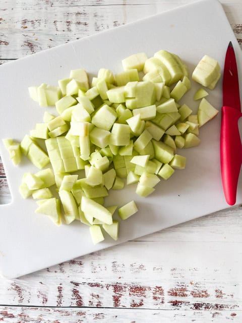 chopped green apples on a white cutting board